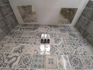 ein Badezimmer mit gefliestem Boden und zwei Spiegeln in der Unterkunft Casas del Castillo Peñíscola-Intramuros Suites in Peñíscola