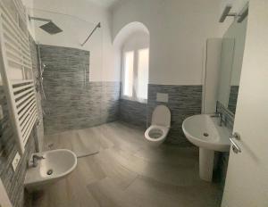 a bathroom with two sinks and a toilet and two mirrors at VILLA IRMA in Varigotti