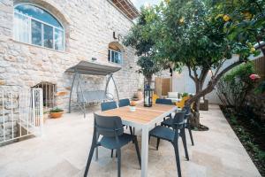 a patio with a table and chairs and a tree at חקל תפוחין in Safed