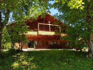 a log cabin with a porch and a balcony on it at Appartement - dans le chalet Carmazin in Morgins