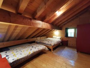- 2 lits dans une chambre dotée de plafonds en bois dans l'établissement Appartement - dans le chalet Carmazin, à Morgins