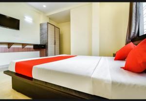 1 dormitorio con 1 cama grande con almohadas rojas en Silver Key Suites, en Nagpur