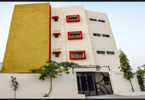 un edificio alto blanco con ventanas rojas. en Silver Key Suites, en Nagpur