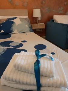 a bed with a blue ribbon on top of it at QLiving Central New Apartments Gzira Sliema Promenade in Il-Gżira
