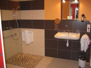 een badkamer met een wastafel en een douche bij Logis Hotel Restaurant Le Cheval Blanc in Charny