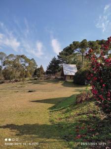 un campo con una casa e dei fiori e un edificio di cabanasluar a São Francisco de Paula Altre 4 foto