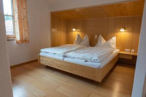 a bedroom with a bed with white sheets and pillows at Frühstückspension Haus Mayr in Hinterstoder