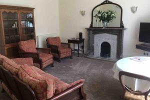 een woonkamer met stoelen en een open haard bij Entire Maisonette Torquay Newly Renovated in Torquay