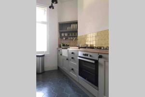 a kitchen with white cabinets and a stove top oven at Entire Maisonette Torquay Newly Renovated in Torquay +9 photos