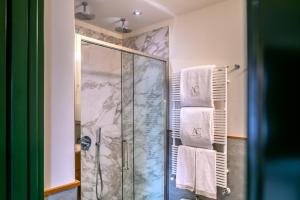 a bathroom with a shower with white towels at Ambra Cortina Luxury&Fashion Hotel in Cortina dʼAmpezzo