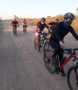 a group of people riding bikes down a dirt road at Cuatro Estaciones in General Rodríguez