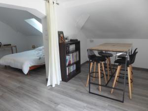 a bedroom with a table and chairs and a bed at Chez Brigitte et Gilbert in Guebwiller