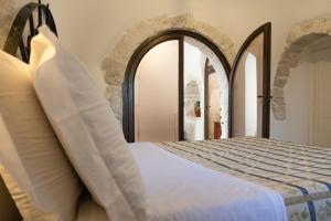 1 dormitorio con cama y puerta abovedada en Masseria Pilano, en Crispiano