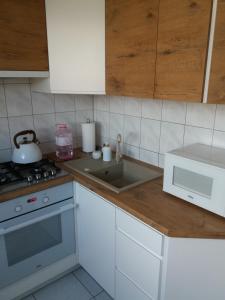 uma cozinha com um lavatório e um fogão forno superior em Urocze mieszkanie z widokiem na Puszczę Białowieską em Hajnówka