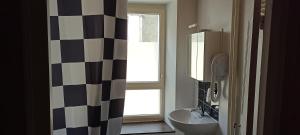 a bathroom with a black and white checkered shower curtain at Gîte de La Bicyclette in Montournais +13 photos