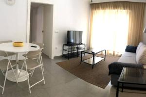 una sala de estar con un sofá y una mesa en AC TRIANA numancia, en Sevilla