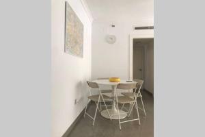 Un comedor blanco con una mesa y sillas. en AC TRIANA numancia, en Sevilla 15 fotos más