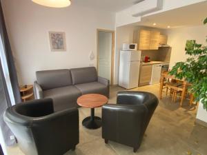 uma sala de estar com um sofá e duas cadeiras e uma mesa em Apparthotel Le Porto em Porto Ota