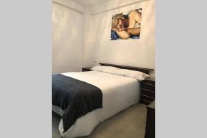 Un dormitorio con una cama y un cuadro en la pared. en AC TRIANA numancia, en Sevilla