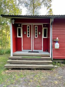 een rood huis met een rode deur en een trap bij KTU Kuntomaja in Kokkola