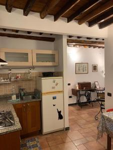 eine Küche mit einem weißen Kühlschrank und einem Tisch in der Unterkunft Le Parole del Gatto in Genua