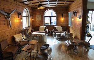 a living room with chairs and tables and windows at Hotel SNOW CHILL in Risoul