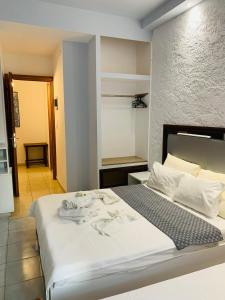 a bedroom with a large white bed in a room at Hotel Platon in Nei Poroi