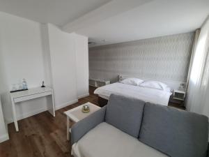 City Hotel Franziska في شتراوبينج: غرفة معيشة مع أريكة وسرير
