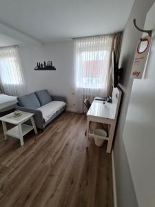 a living room with a couch and a table at City Hotel Franziska in Straubing