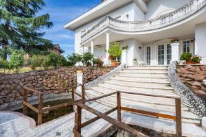 a white house with stairs and a stone wall at White House in Lainate