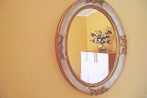 a mirror hanging on a wall with a vase of flowers at Il Gioiellino in Lucca
