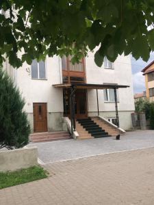 un edificio con porche y escaleras delante en Manchela садиба en Vygoda
