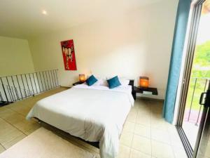 1 dormitorio con cama blanca y ventana grande en Mini Casa Cozy and Peaceful Beach Apartment, en Playa Grande