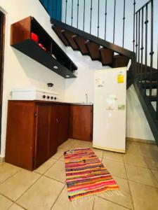 a kitchen with a refrigerator and a staircase at Mini Casa Cozy and Peaceful Beach Apartment in Playa Grande