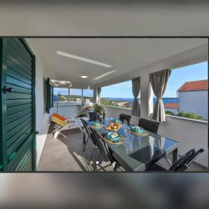 a dining room with a table and chairs and the ocean at Holiday home Petra - house with a sea view in an isolated location in Vinišće