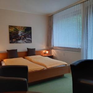 a bedroom with two beds and a window at Pension Im Rehwinkel in Soltau