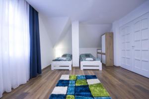 1 dormitorio con 2 camas y alfombra en SunGarden Vendégház, en Sajószöged
