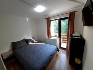 um quarto com uma cama azul e uma janela em Casa Haiducilor em Predeal