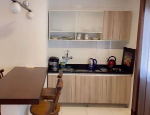 een keuken met een tafel en een aanrecht bij Flat Deluxe Gramado in Gramado