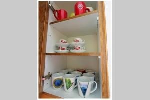 a cupboard filled with lots of cups and saucers at Top of the hill in Drepano-Nafplio, Beautiful view in Dhrepanon