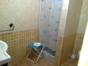 a shower with a blue stool in a bathroom at Fiorerosa in Santa Maria Navarrese