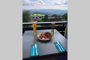 a table with a bowl of food on a balcony at Apartment Tälerblick in Böbrach