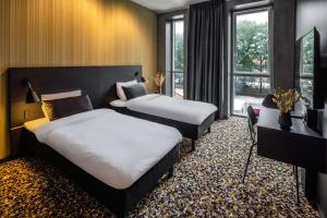 um quarto de hotel com duas camas e uma janela em Peak 12 Hotel em Viborg