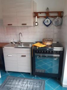 a kitchen with a stove and a sink at da paola in Iglesias