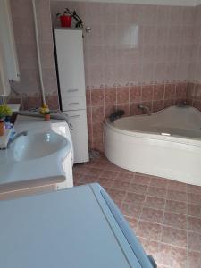 a bathroom with a bath tub and a sink at Guest house Obzor in Obzor