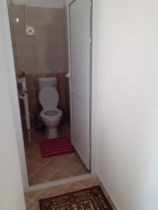 a bathroom with a toilet and a glass shower door at Guest house Obzor in Obzor