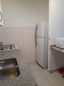 eine Küche mit einer Spüle und einem weißen Kühlschrank in der Unterkunft Parque Patricios 2 ambientes in Buenos Aires