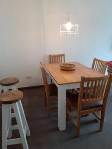 drewniany stół z krzesłami oraz stół i stołek w obiekcie Parque Patricios 2 ambientes w BuenosAires