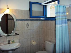 uma casa de banho com um lavatório, um WC e um espelho. em Villa Orizontes em Spetses