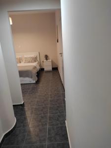 a bedroom with a bed and a tiled floor at Double M near Athens Airport in Markopoulo